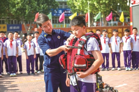 <br>          ■5月12日，河北省遵化市第一实验小学的学生在消防救援人员的帮助下体验救生衣穿戴 ■供图/新华社<br><br>        