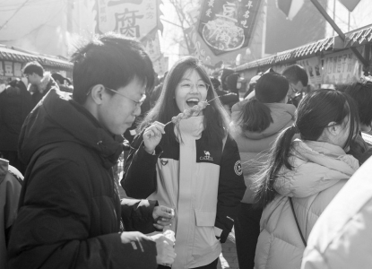 <br>          ■2月8日，在北京市昌平区沙河大集，一名女孩在品尝特色小吃<br><br>        